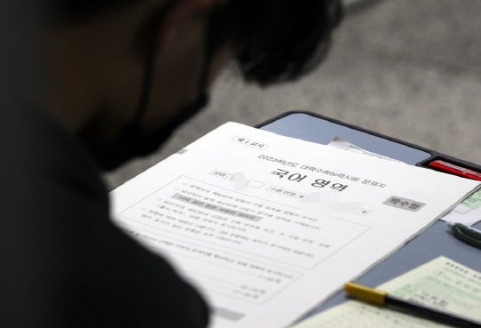2023학년도 대학수학능력시험일인 17일 한 고등학교에 마련된 고사장에서 수험생들이 시험지를 받아들고 있다. <사진공동취재단>